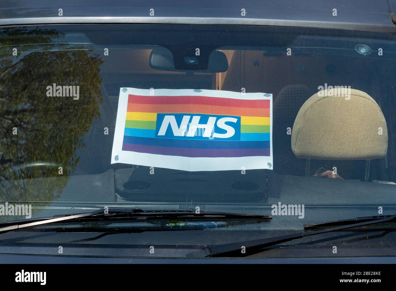 10. April 2020. Ein NHS-Poster in einer Autoscheibe, das das Fahrzeug zeigt, gehört einem Mitarbeiter des NHS. Während der Pandemie des Coronavirus Covid-19 von 2020 ist der Regenbogen zum Symbol der Unterstützung für Menschen geworden, die Solidarität mit den Beschäftigten des Gesundheitsdienstes an der Front zeigen wollen. Stockfoto