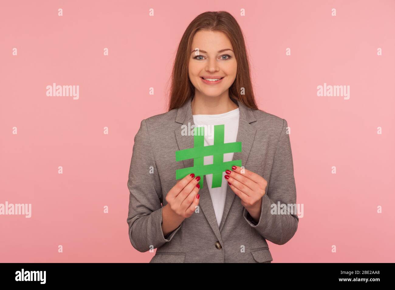Hash-Zeichen. Porträt von positiven eleganten Frau in Business-Anzug halten Papier Hashtag Symbol, Förderung von Web-Content und virale Internet-Ideen, Blog-Marke Stockfoto