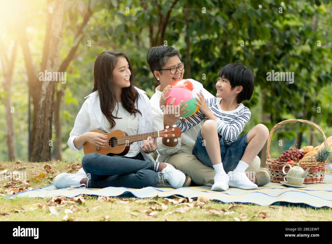 Glückliche Familie mit Oma, Mama und Sonne im Park, genießen und entspannen Menschen Picknick draußen Stockfoto