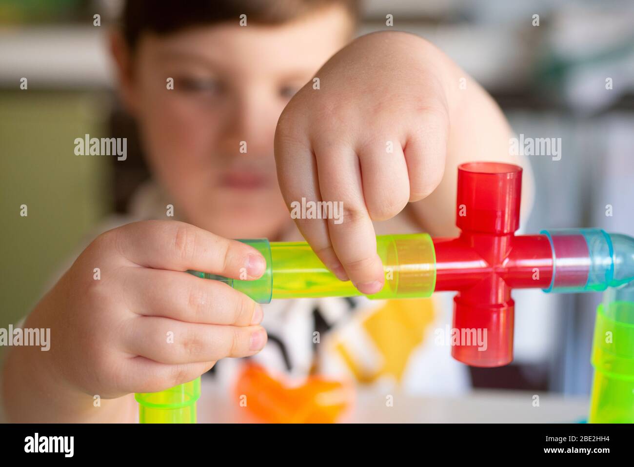 Spielen Little Boy mit farbigen Tubes Stockfoto