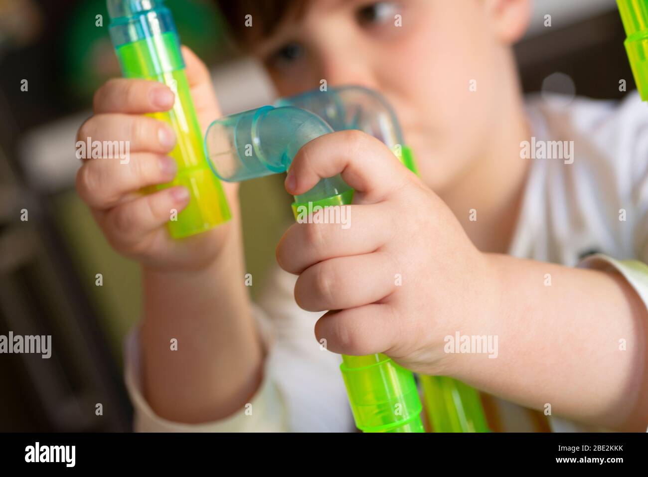 Spielen Little Boy mit farbigen Tubes Stockfoto