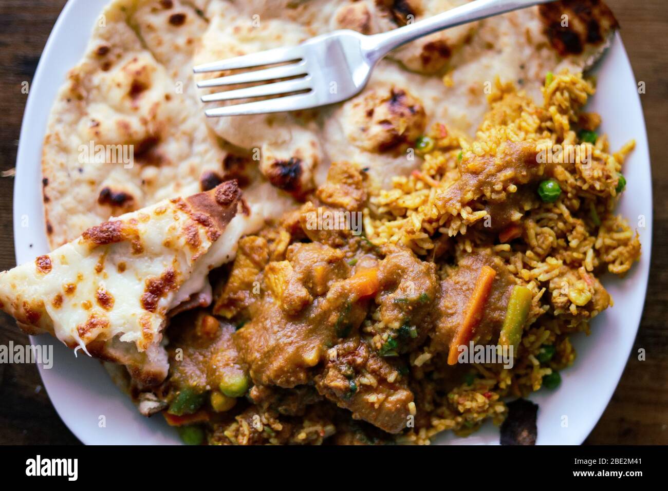 Ein Teller mit indischem Essen mit Huhn biriyani, Huhn tikka Masala und Naan Brot Stockfoto