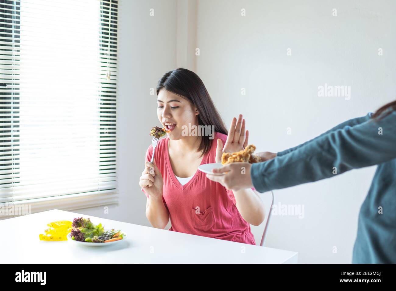 Diät Frau ablehnen Chicken Pommes, ungesunde frittierte Lebensmittel zu vermeiden und Gemüse und Salat auf dem Tisch zu essen Stockfoto