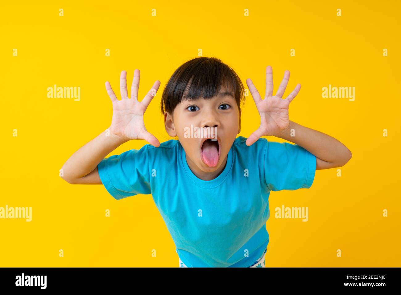 Porträt von jungen asiatischen Mädchen Ausdruck und fröhlich, Thai Kind Spaß und Unschuld auf gelbem Hintergrund haben Stockfoto