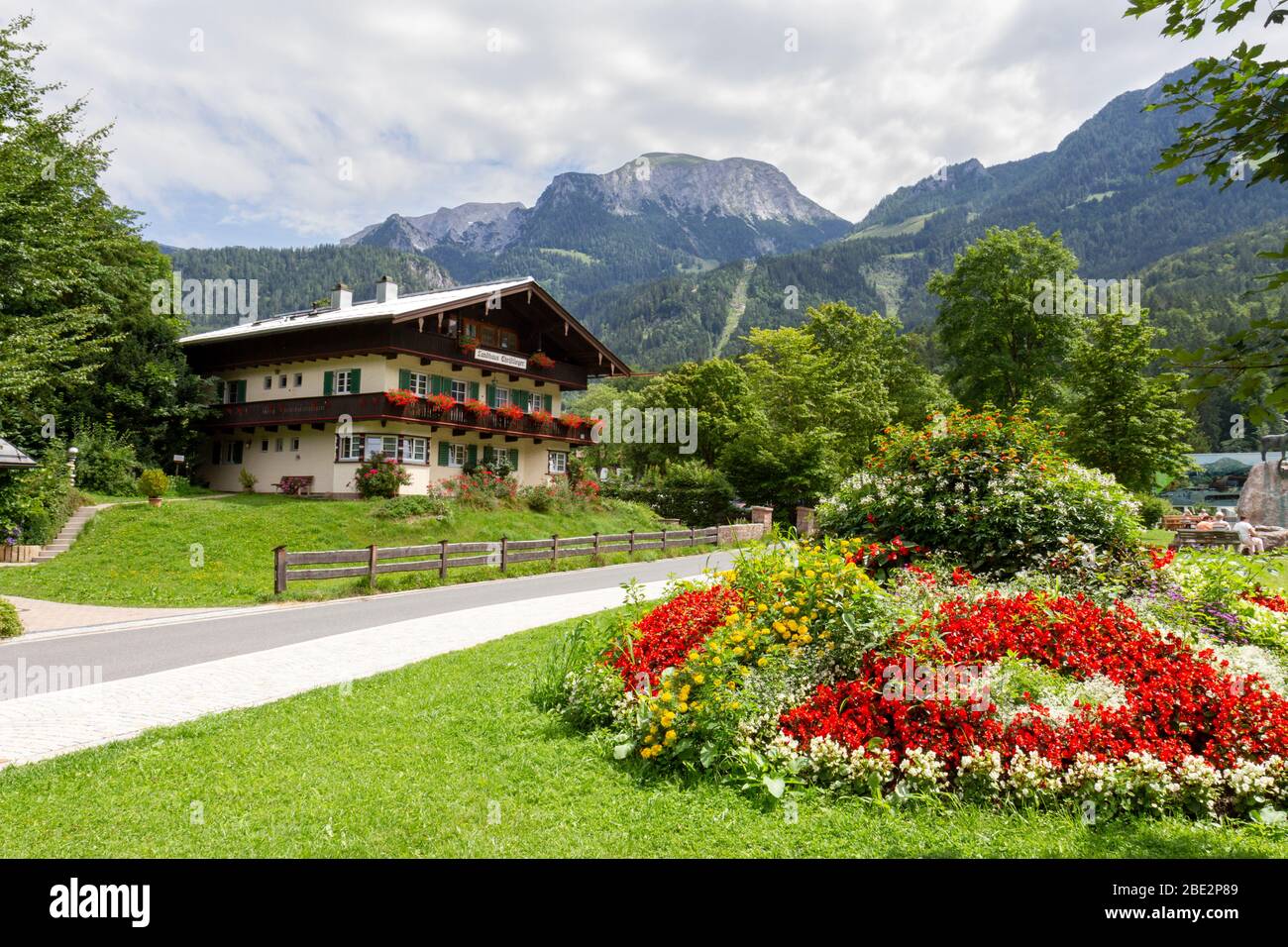 Blick auf Landhaus Christlieger mit Bergen an der deutsch-österreichischen Grenze von Königssee, Bayern, Deutschland. Stockfoto