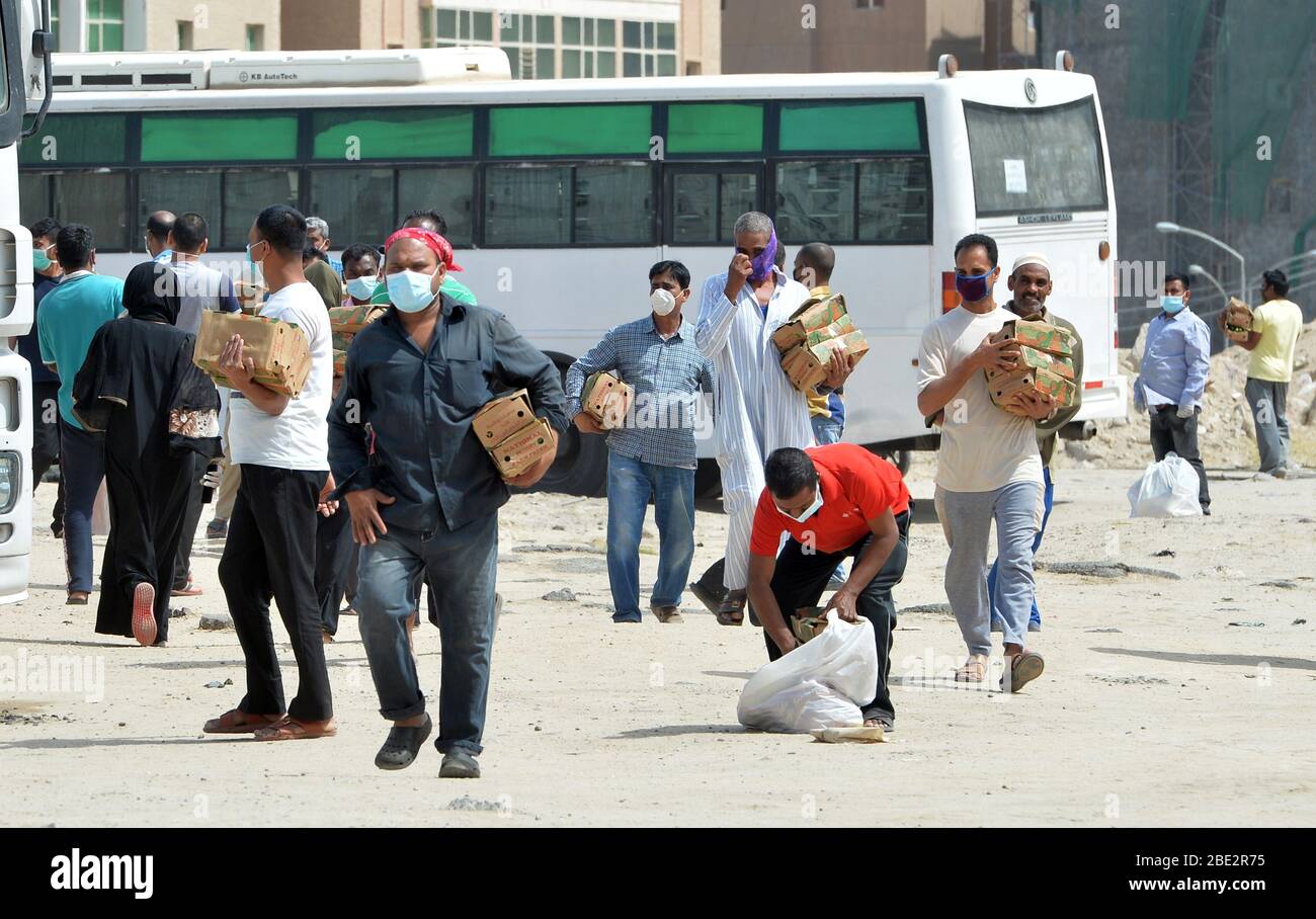 Ahmadi Governorate, Kuwait. April 2020. Die Bewohner des Gebiets von Mahboula tragen Lebensmittel, die von der Regierung nach der Sperrung des Gebiets verteilt wurden, um die Ausbreitung des neuartigen Coronavirus zu verhindern, in Ahmadi Governorate, Kuwait, 11. April 2020. Die kuwaitische Regierung hat beschlossen, die Gebiete Mahboula und Jleeb Al-Shuyoukh für zwei Wochen komplett abzusperren. Kuwait berichtete am Samstag 161 neue COVID-19 Fälle, wodurch die Gesamtzahl der bestätigten Fälle im Land auf 1,154, sagte das Gesundheitsministerium in einer Erklärung. Kredit: Asad/Xinhua/Alamy Live News Stockfoto