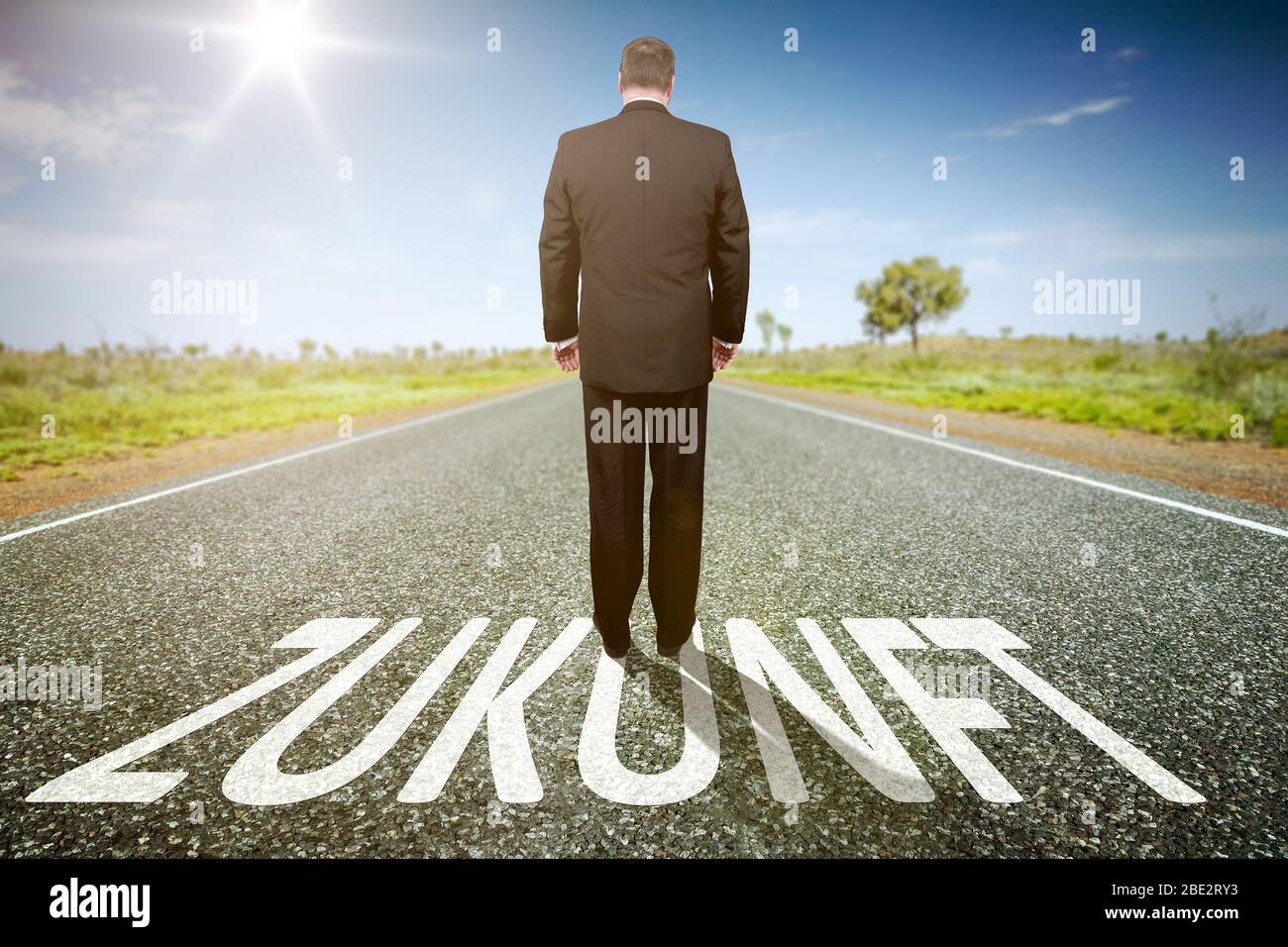Ein Geschaeftsmann auf einer einsamen Straße, auf der 'Zukunft' steht Stockfoto