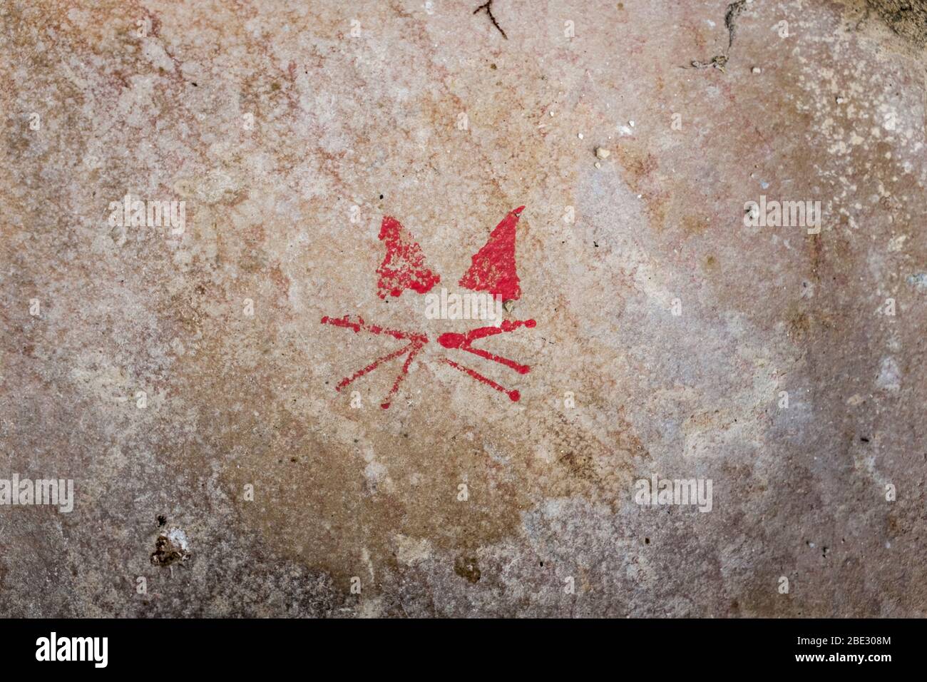 Das französische Dorf La Romieu ist berühmt für seine Verbindung mit Katzen und diese stilisierte rot bemalte Katze ist an einer Wand im Dorf. Stockfoto