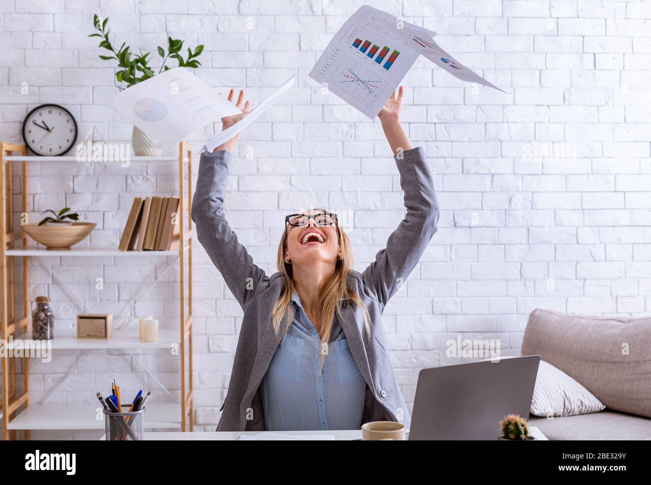 Guten Tag bei der Arbeit. Frau wirft Papiere auf Stockfoto