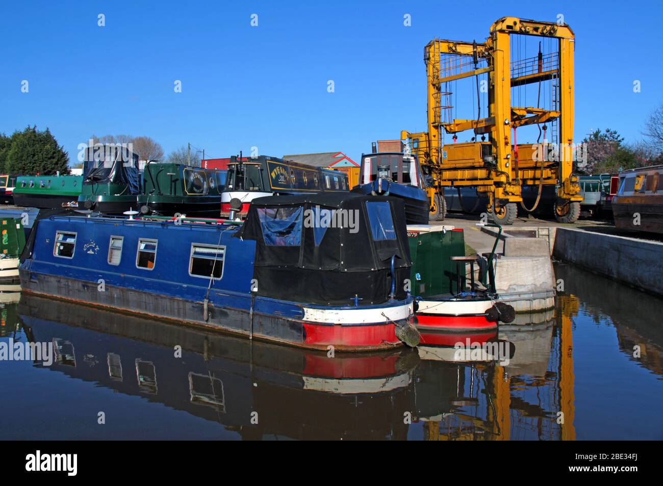 Canal Narrowboats und Kranlift bei Park Farm Marina Limited, Wincham Wharf, Lostock Gralam, Northwich, Cheshire, England, UK, CW9 7NT Stockfoto