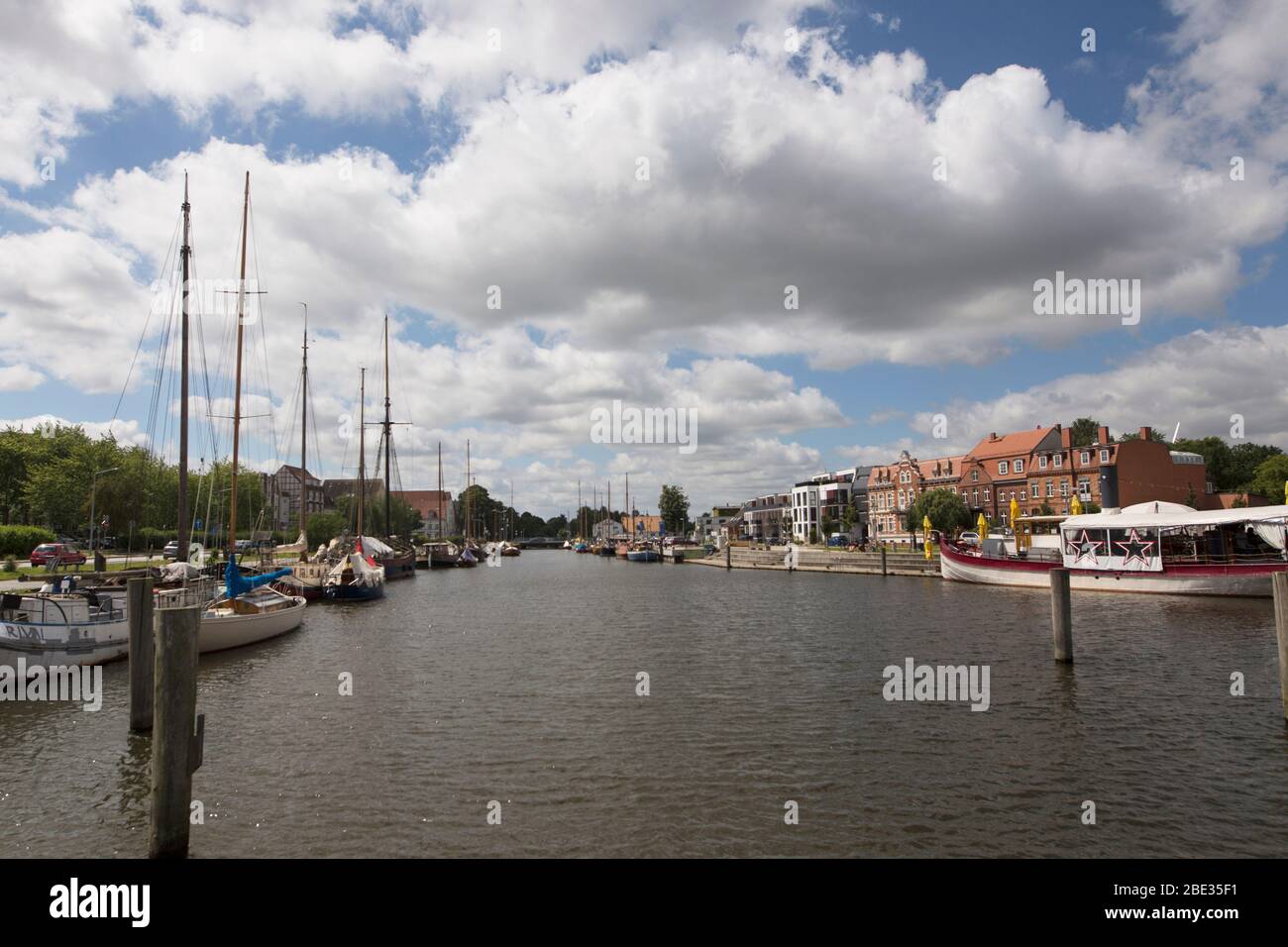 Boote und Gebäude entlang des Ryck an einem Sommertag in Greifswald, Deutschland. Stockfoto