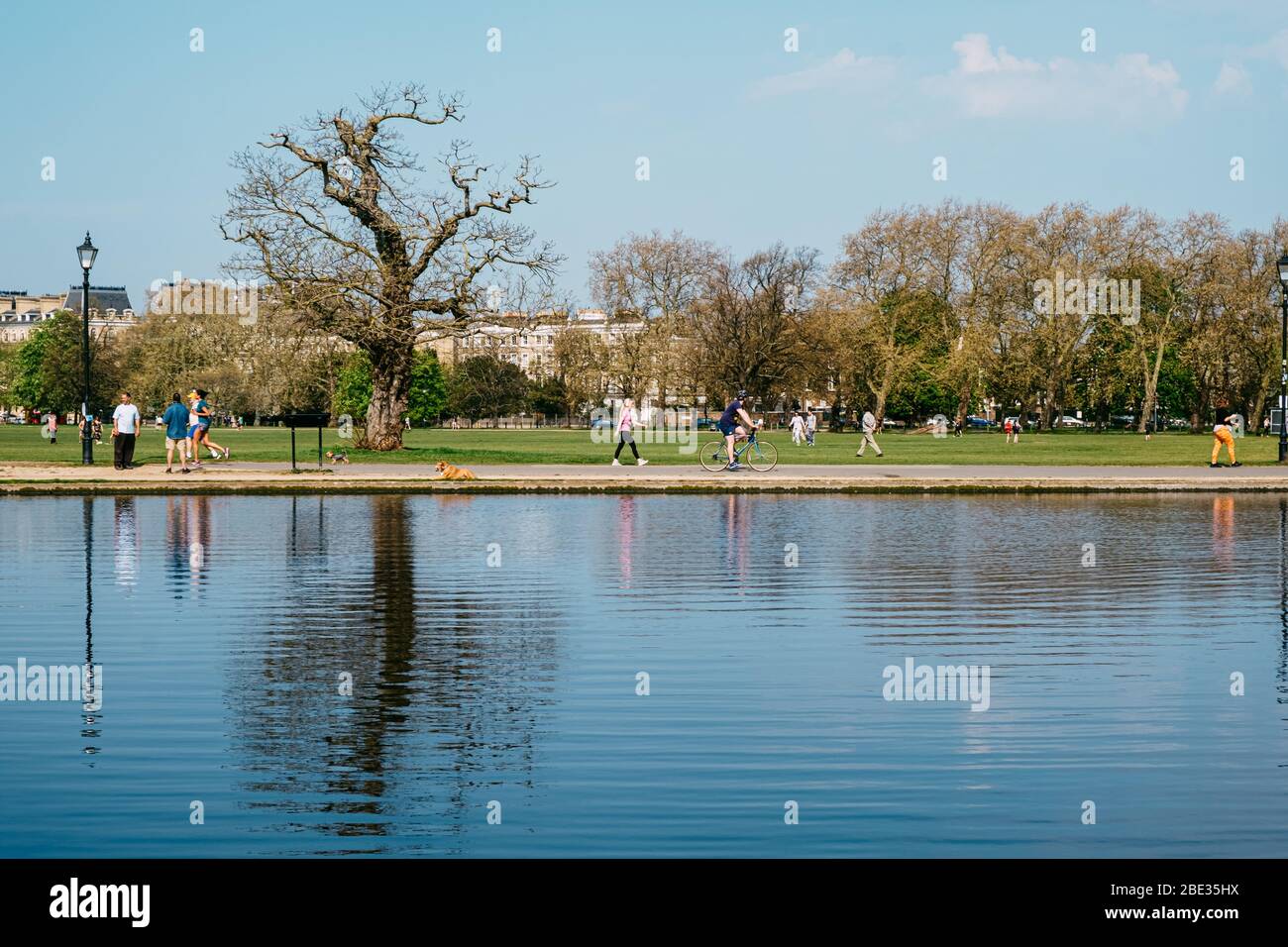 Clapham Common, London, Großbritannien. April 2020. Jogger und Radfahrer reflektierten sich am Osterwochenende im langen Teich und der Corona Virus Lockdown. Kredit: Tom Leighton/Alamy Live News Stockfoto