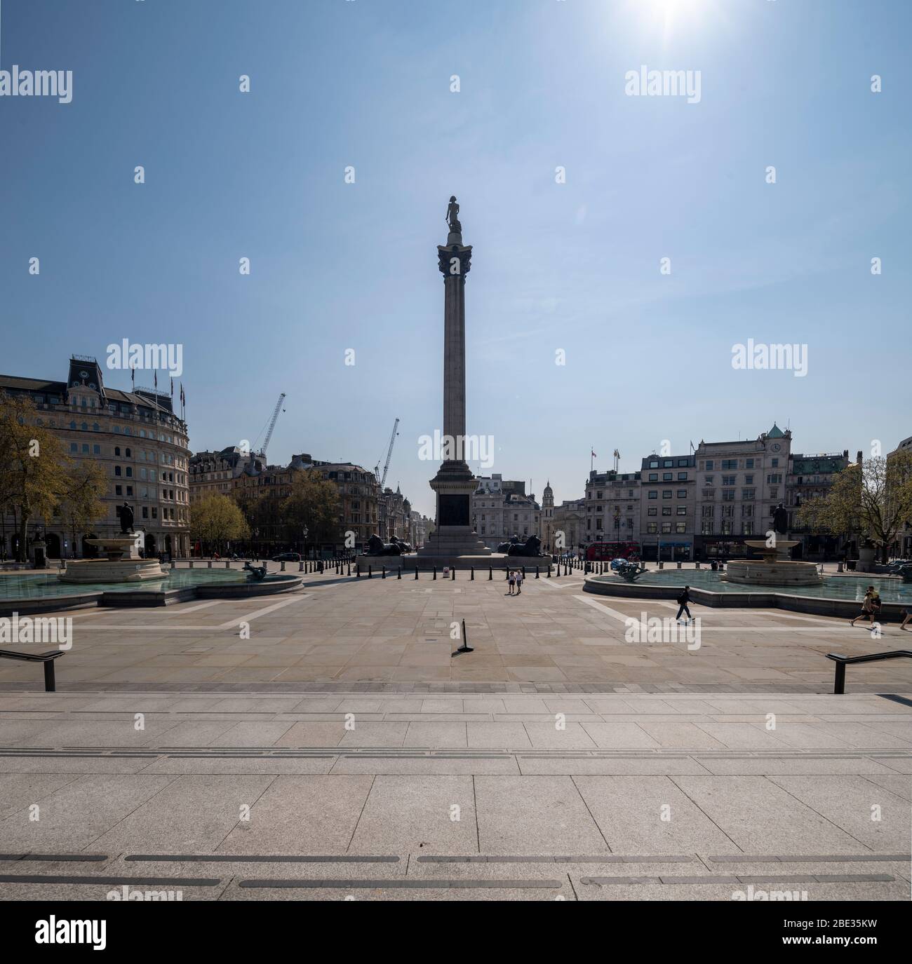 Ein sonniger Frühlingstag im leeren, menschenleeren und ruhigen Trafalgar Square, London während Covid 19, erzwang die Coronavirus-Grippe-Pandemie die Sperrung. Stockfoto