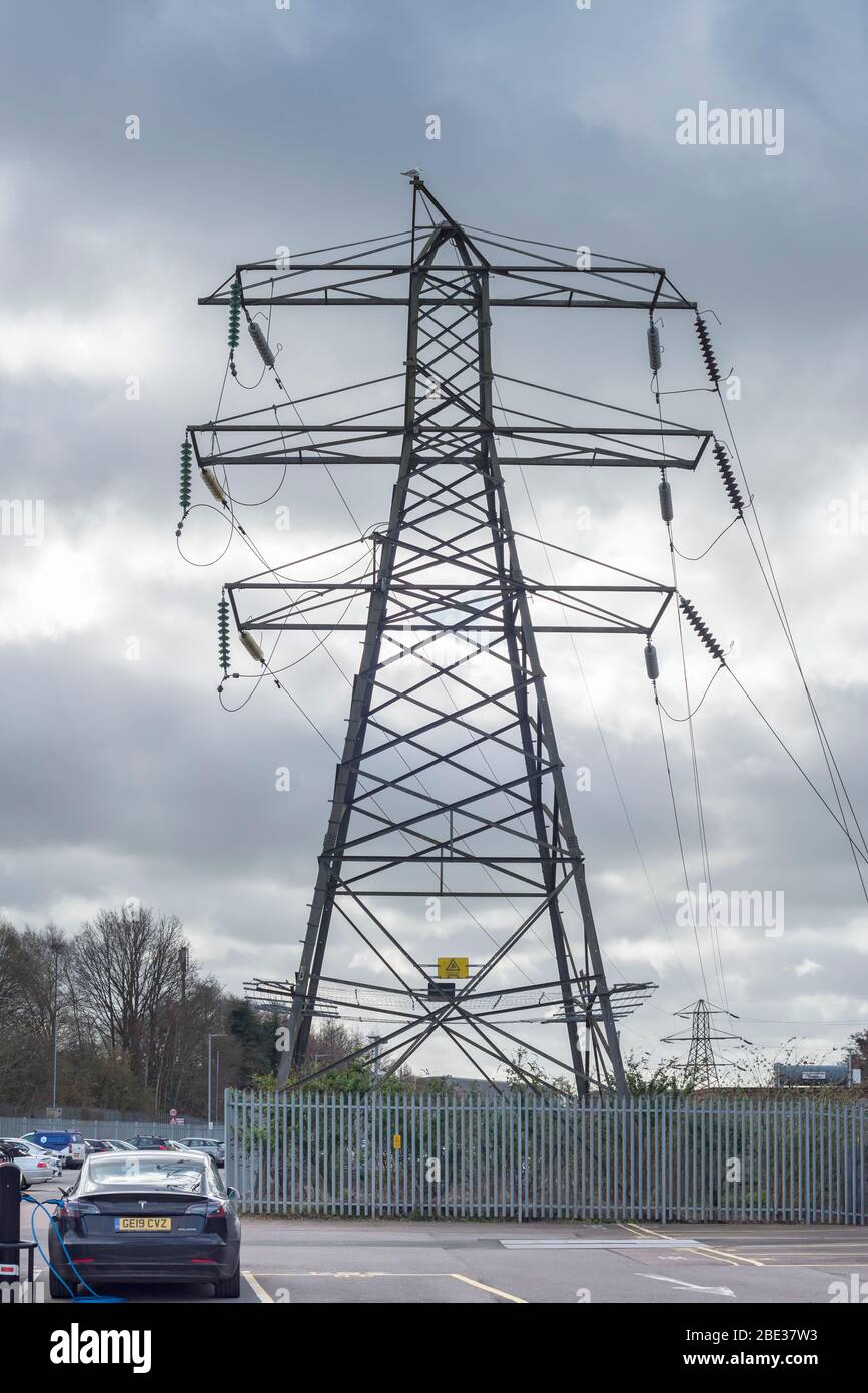 Elektroautos auf Ladung neben einem Strompylon Stockfoto