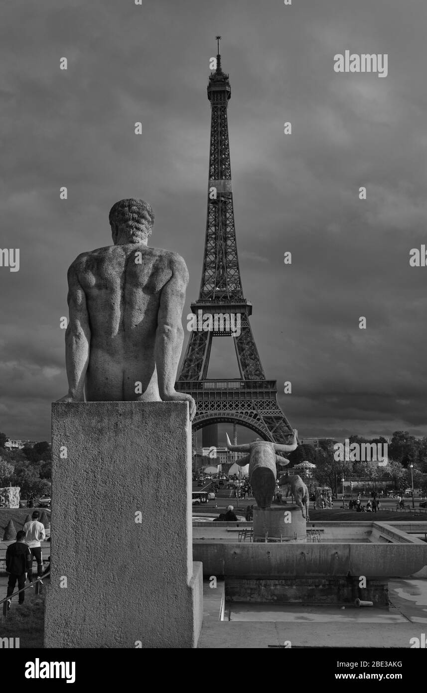 Statue des sitzenden Mannes, der auf den Eiffelturm schaut Stockfoto