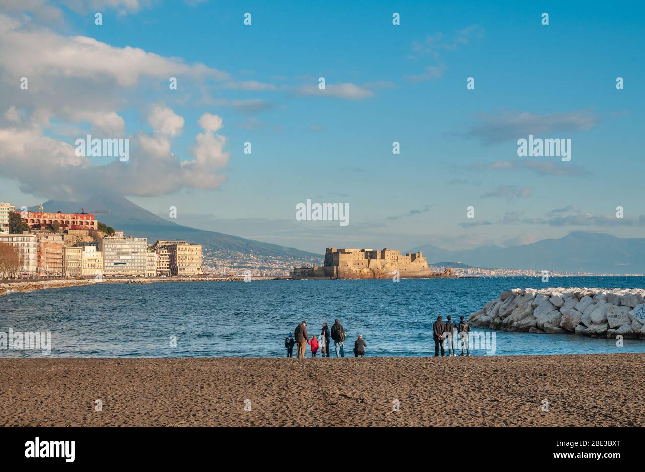 Eine Gruppe von Menschen bewundern die Küste von Neapel von einem Stadtstrand aus gesehen. Stockfoto