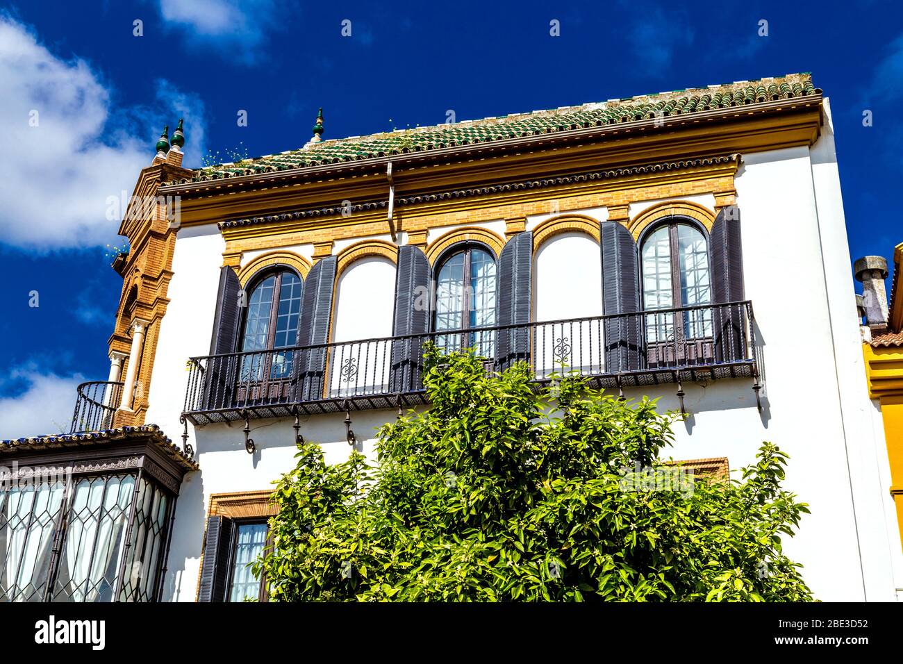 Spanische Architektur, weißes und gelbes Gebäude mit Fensterläden in Sevilla, Andalusien, Spanien Stockfoto