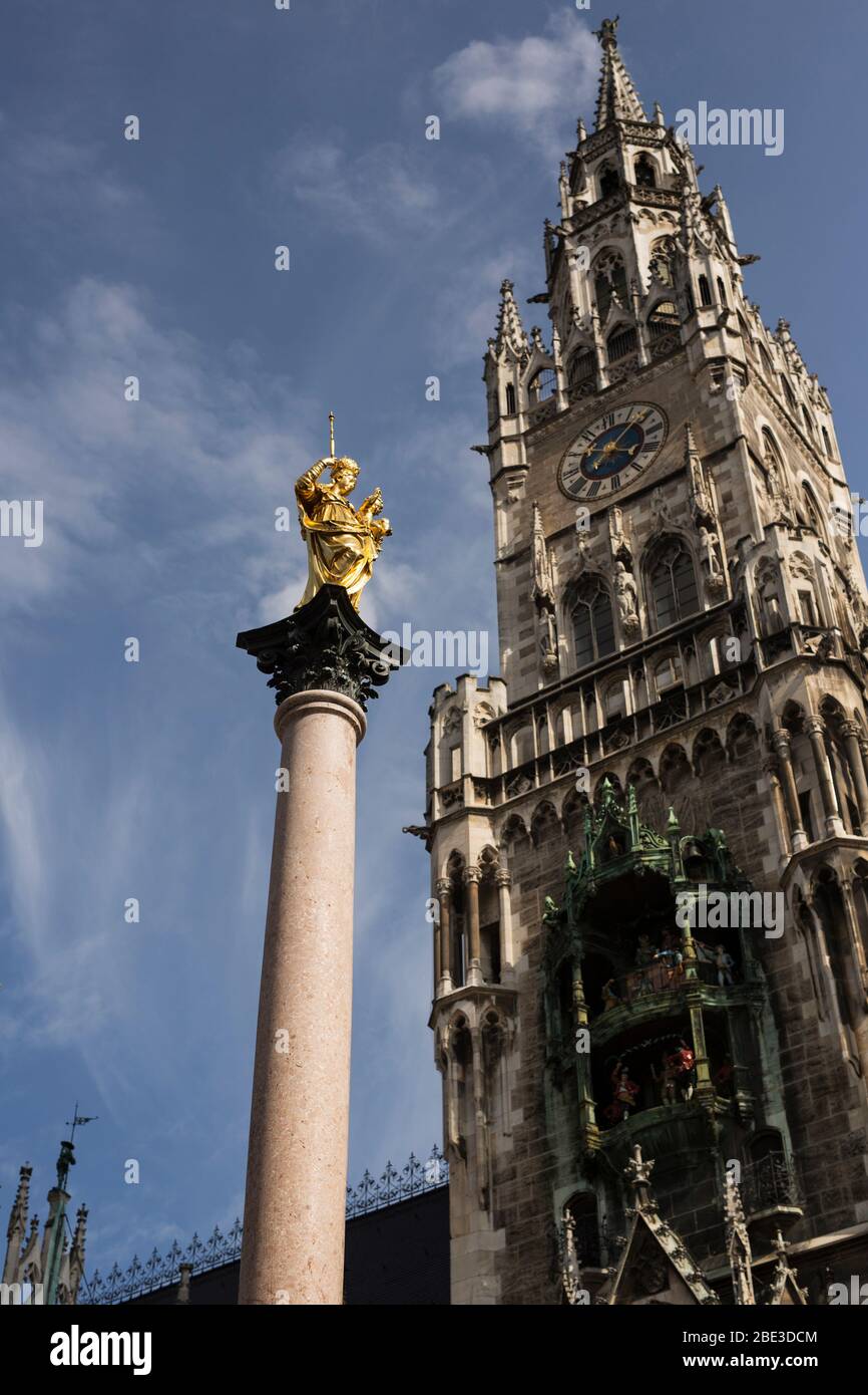 Die Mariensäule vor dem Neuen Rathaus auf dem Marienplatz in München, mit Uhrturm und Glockenspiel. Stockfoto