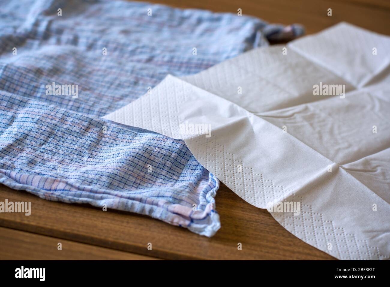 Papiertaschentuch und ein Baumwollhandtuch. Coronavirus Beratung umfasst die Verwendung eines Einweg-Papiertuch anstelle eines Baumwollgewebes Stockfoto