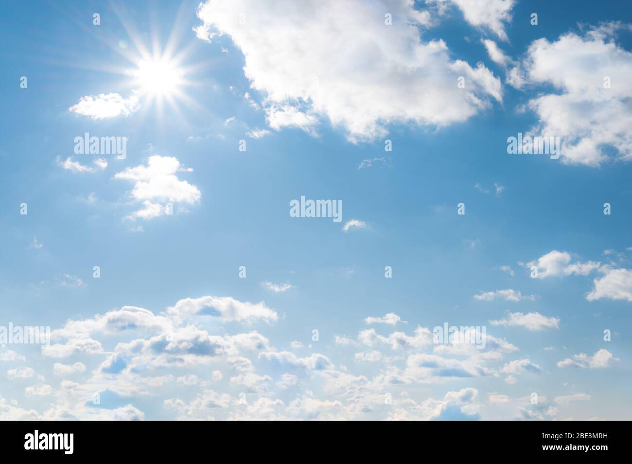 Sonne mit Sonnenstrahlen auf den blauen Himmel mit weißen Wolken. Tagsüber und bei schönem Wetter Stockfoto