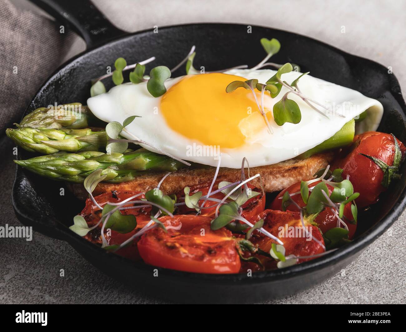 Spiegelei auf Toast mit gerösteten Tomaten Spargel Frühstück, gesunde Lebensmittel Nahaufnahme Stockfoto