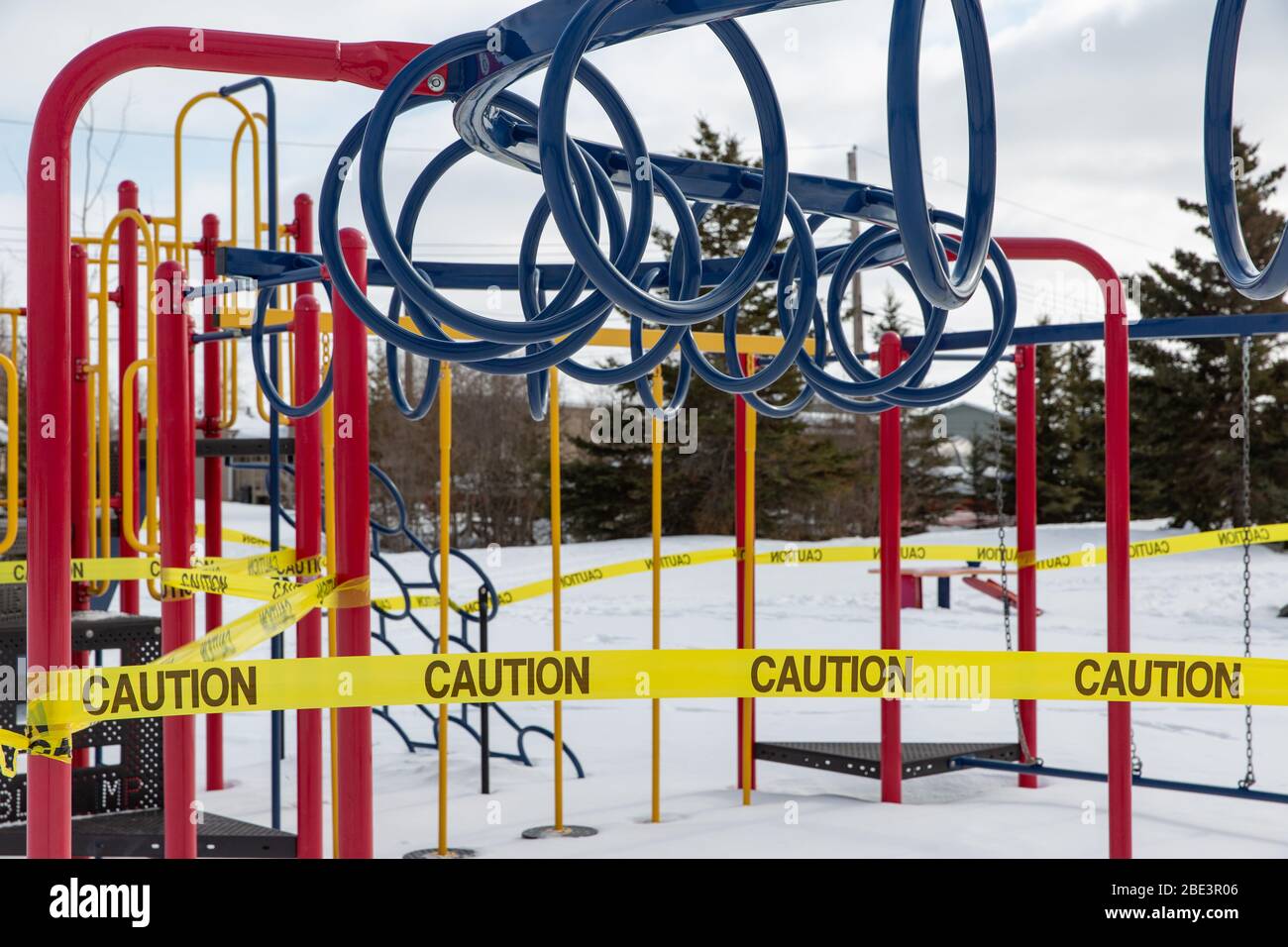 Schließung des Spielplatzes und der Ausrüstung, eingewickelt in Schutzband, Coronavirus Covid-19 Pandemie, Winter, Yellowknife, Northwest Territories, April 2020. Stockfoto