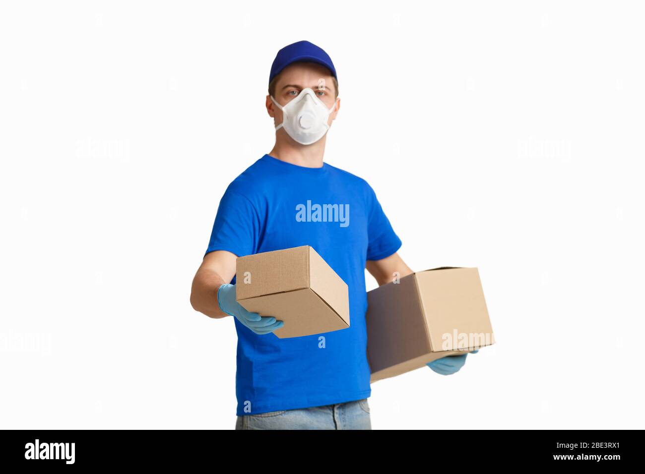 Deliveryman in medizinischen Maske hält Box Stockfoto
