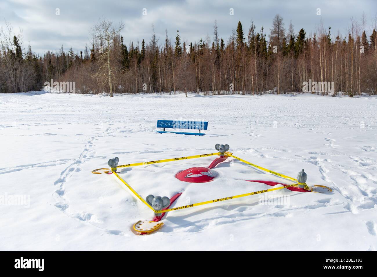 Parksperrung und Spielplatzausrüstung in Schutzband eingewickelt, während einer Coronavirus-Pandemie, Winter, Yellowknife, Northwest Territories, April 2020. Stockfoto