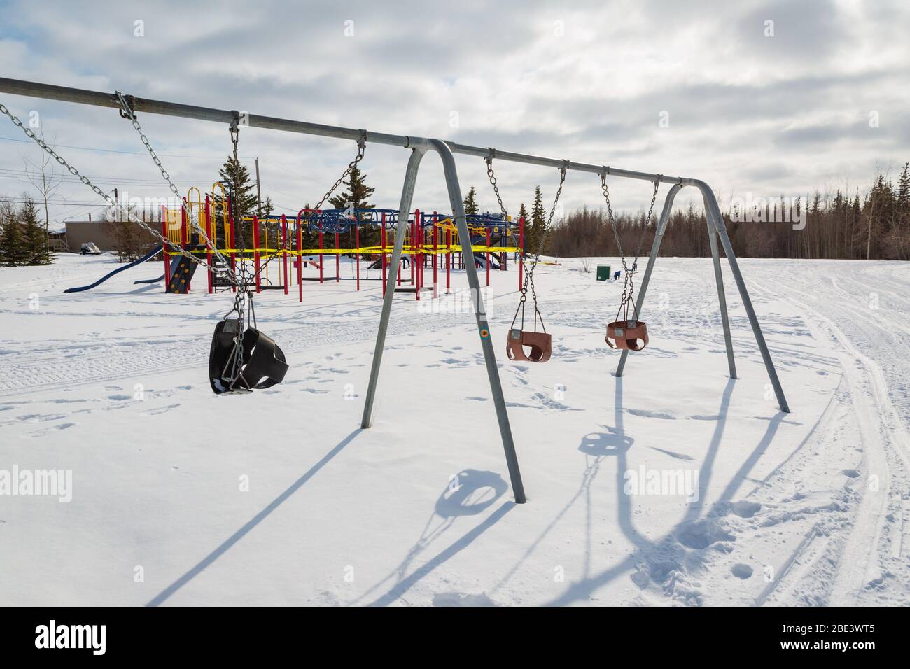 Schließung des Spielplatzes und festgelegter Schaukel während der Coronavirus Covid-19 Pandemie im Winter, Yellowknife, Northwest Territories, Kanada, April 2020. Stockfoto