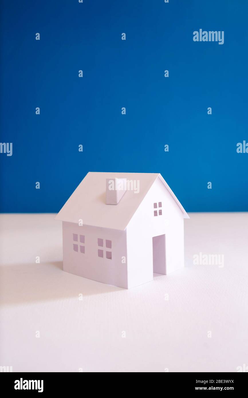 Ganz weißes Papier Miniaturhaus mit blauem Hintergrund Stockfoto