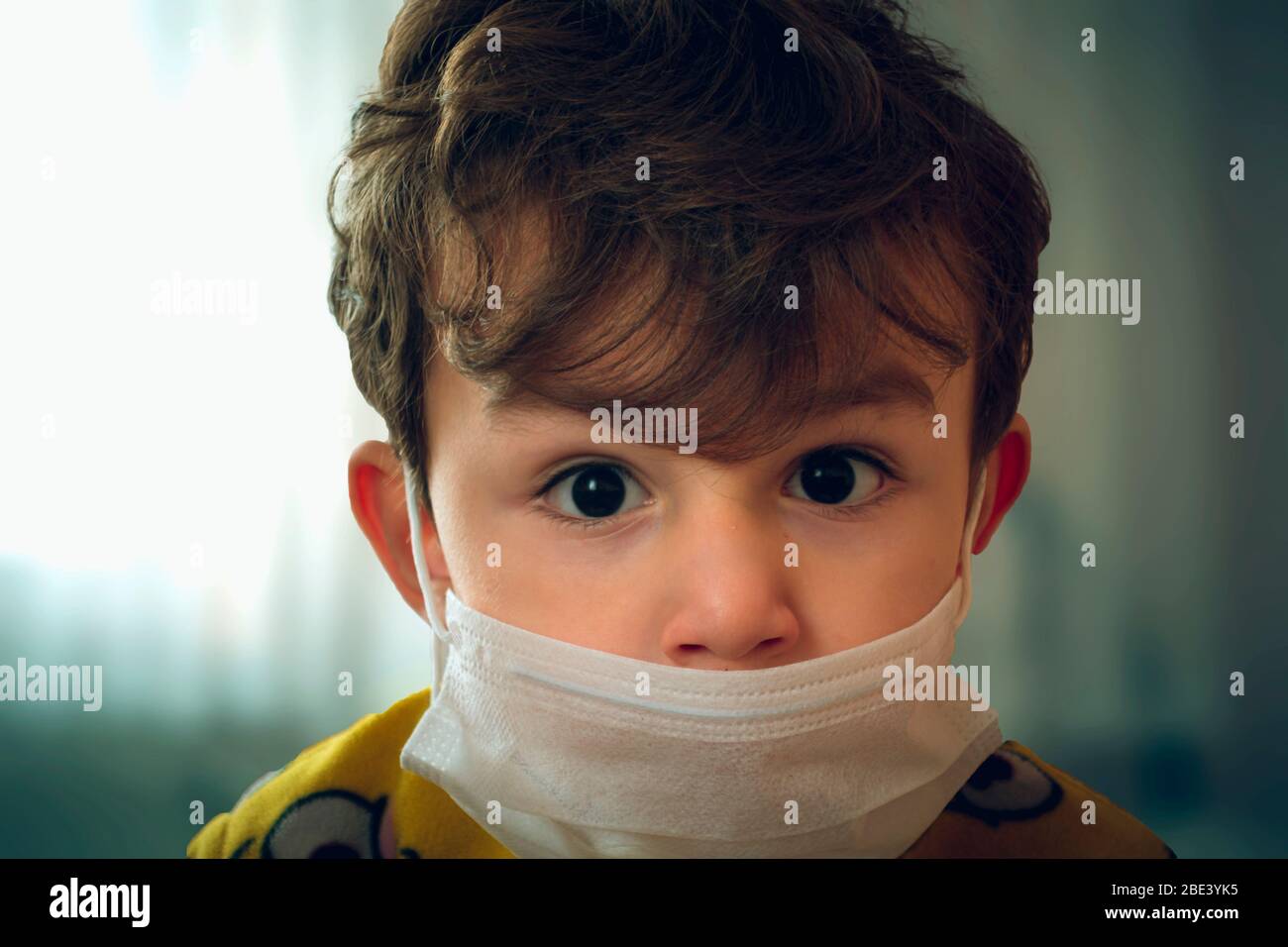 3 Jahre altes türkisches Baby mit chirurgischer Maske, das ängstlich auf die Kamera gucken kann Stockfoto
