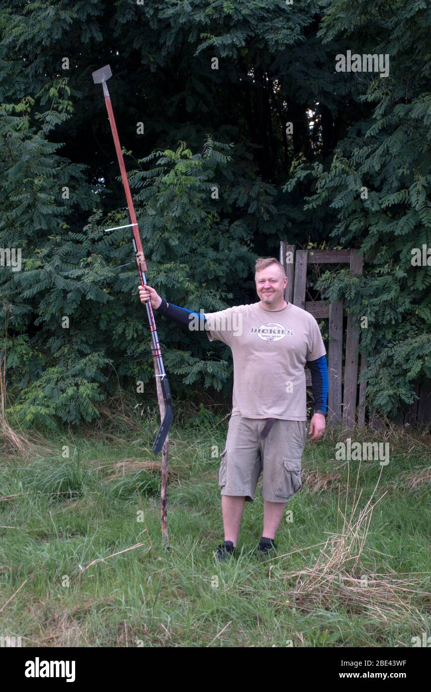 Papa hält improvisierte lange Stange, um einen Drachen in den Bäumen gefangen zu ziehen. Zawady Gmina Rzeczyca Polen Stockfoto