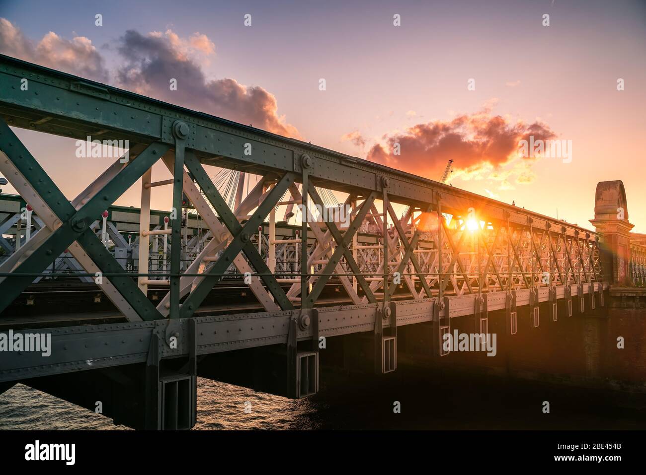 Das berühmte Hungerford und die Golden Jubilee Bridge unter lebhaftem Sonnenuntergang an der Themse in der Nähe von Southbank, London, Großbritannien Stockfoto