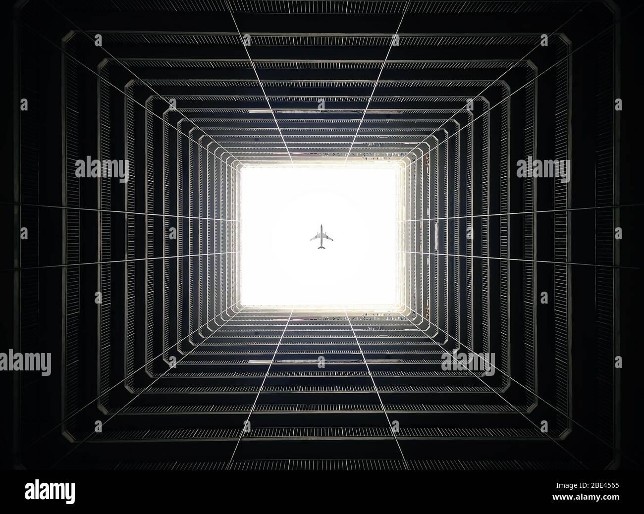 Passagierflugzeug Fliegen Sie über das Atrium des dunklen Gebäudes in den dunklen Schatten, Hongkong Stockfoto