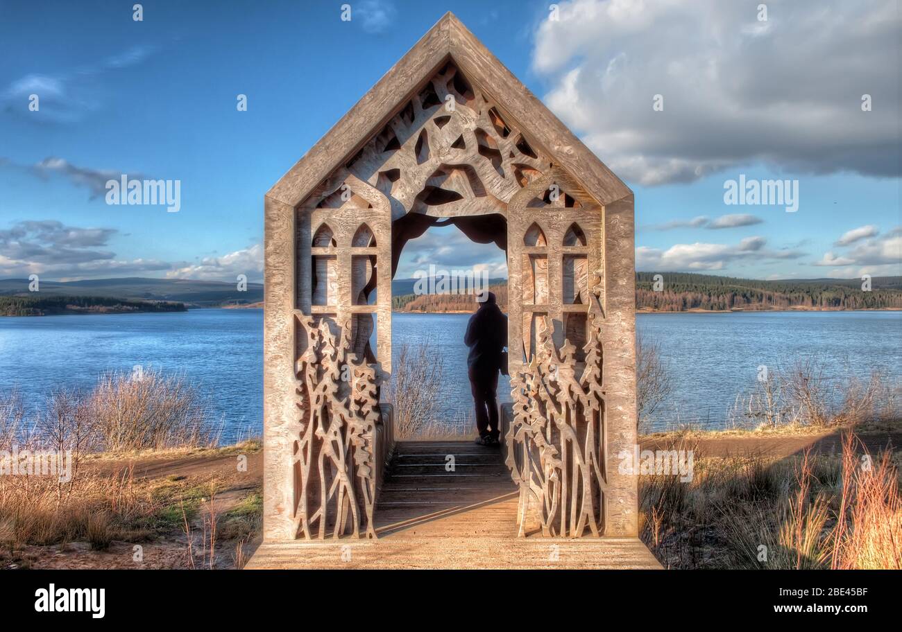 Holzhütte mit Schnitzereien in der Nähe eines Sees im Kielder Water & Forest Park, Großbritannien Stockfoto