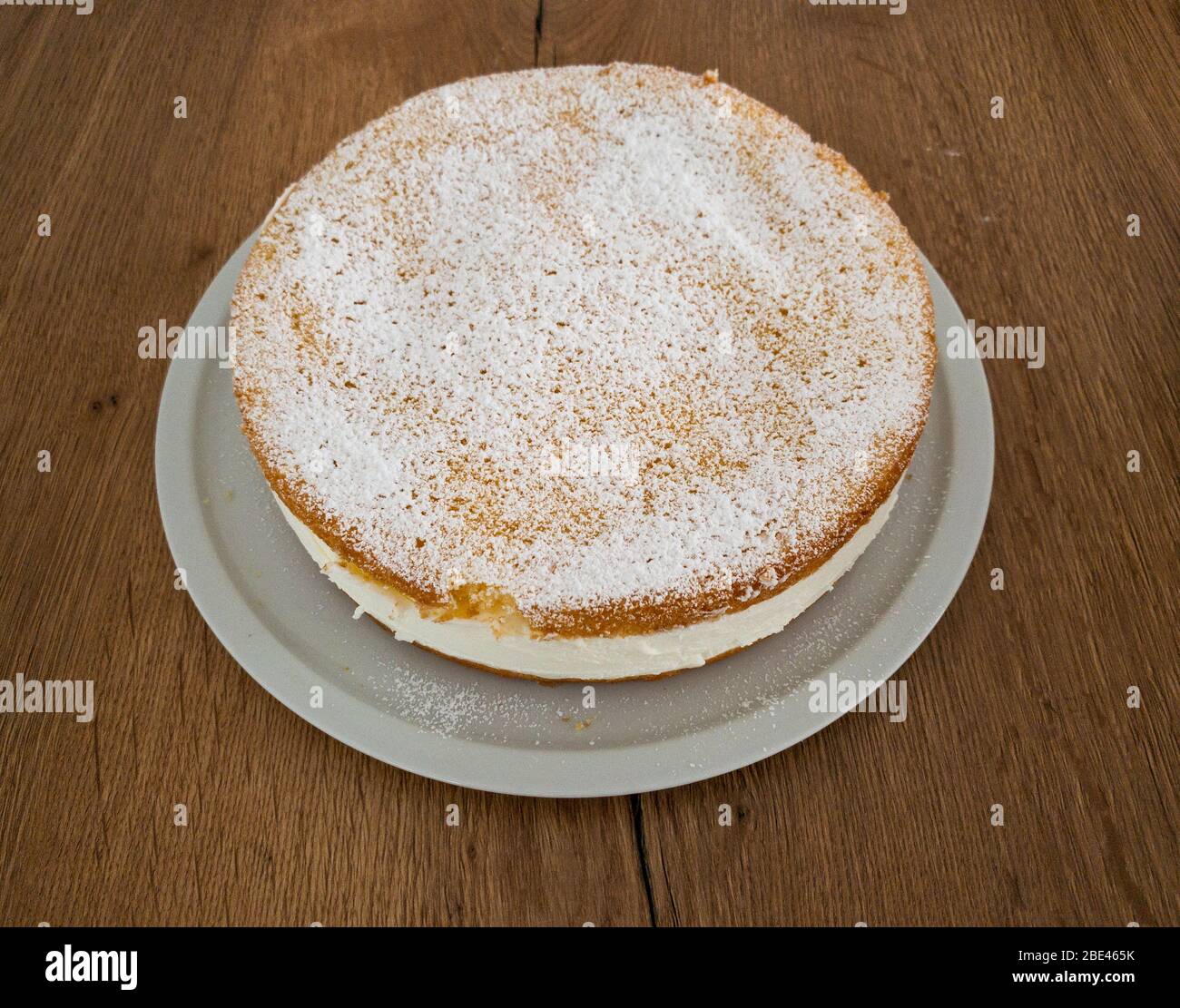 Ein kompletter, ungeschnittener leckerer Käsekuchen aus Seitenansicht. Stockfoto