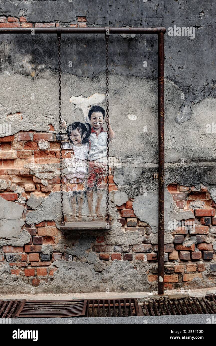 Kinder auf einer Schaukel, Kunstwerke von Louis Gan in Penang, Malaysia - Niños en un columpio, obra de arte de Louis Gan en Penang, Malasia Stockfoto