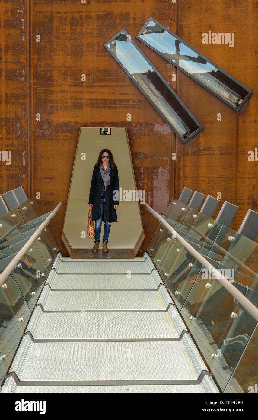 Eine Touristenin bewegt sich durch die beeindruckende Kunst und Architektur des Mueum of Old and New Art in Hobart, Tasmanien. Stockfoto