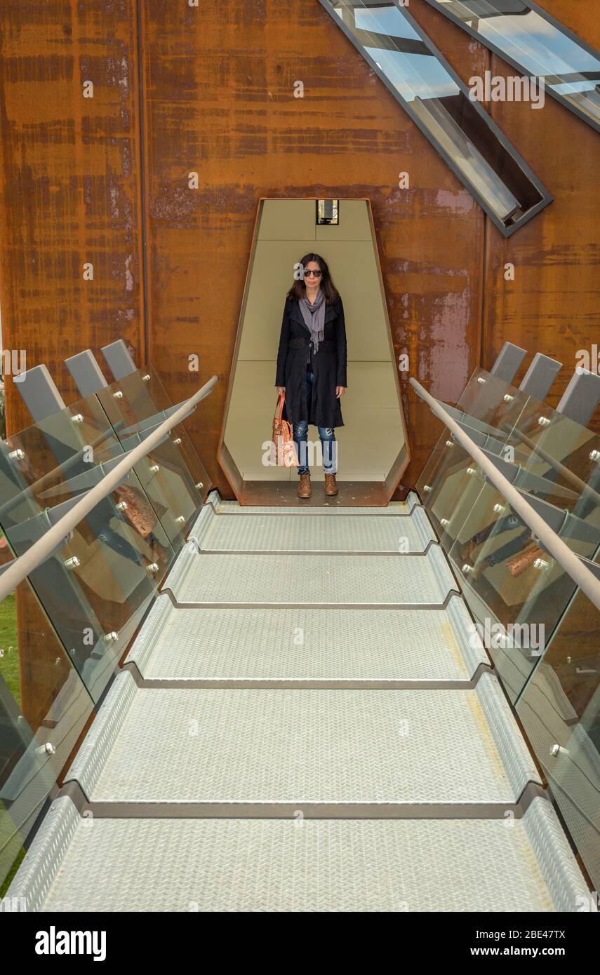 Eine Touristenin bewegt sich durch die beeindruckende Kunst und Architektur des Mueum of Old and New Art in Hobart, Tasmanien. Stockfoto