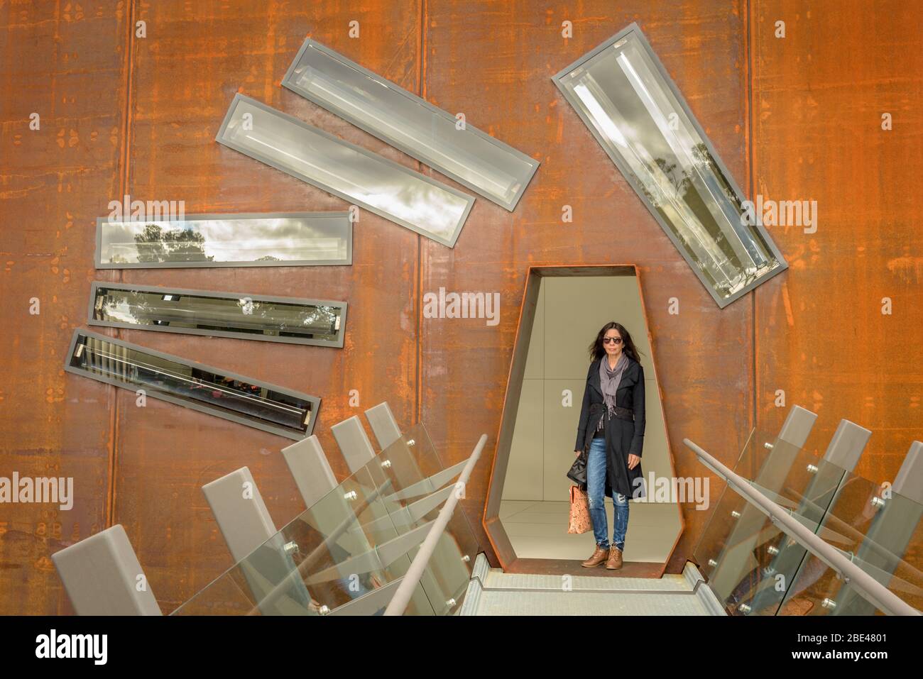 Eine Touristenin bewegt sich durch die beeindruckende Kunst und Architektur des Mueum of Old and New Art in Hobart, Tasmanien. Stockfoto