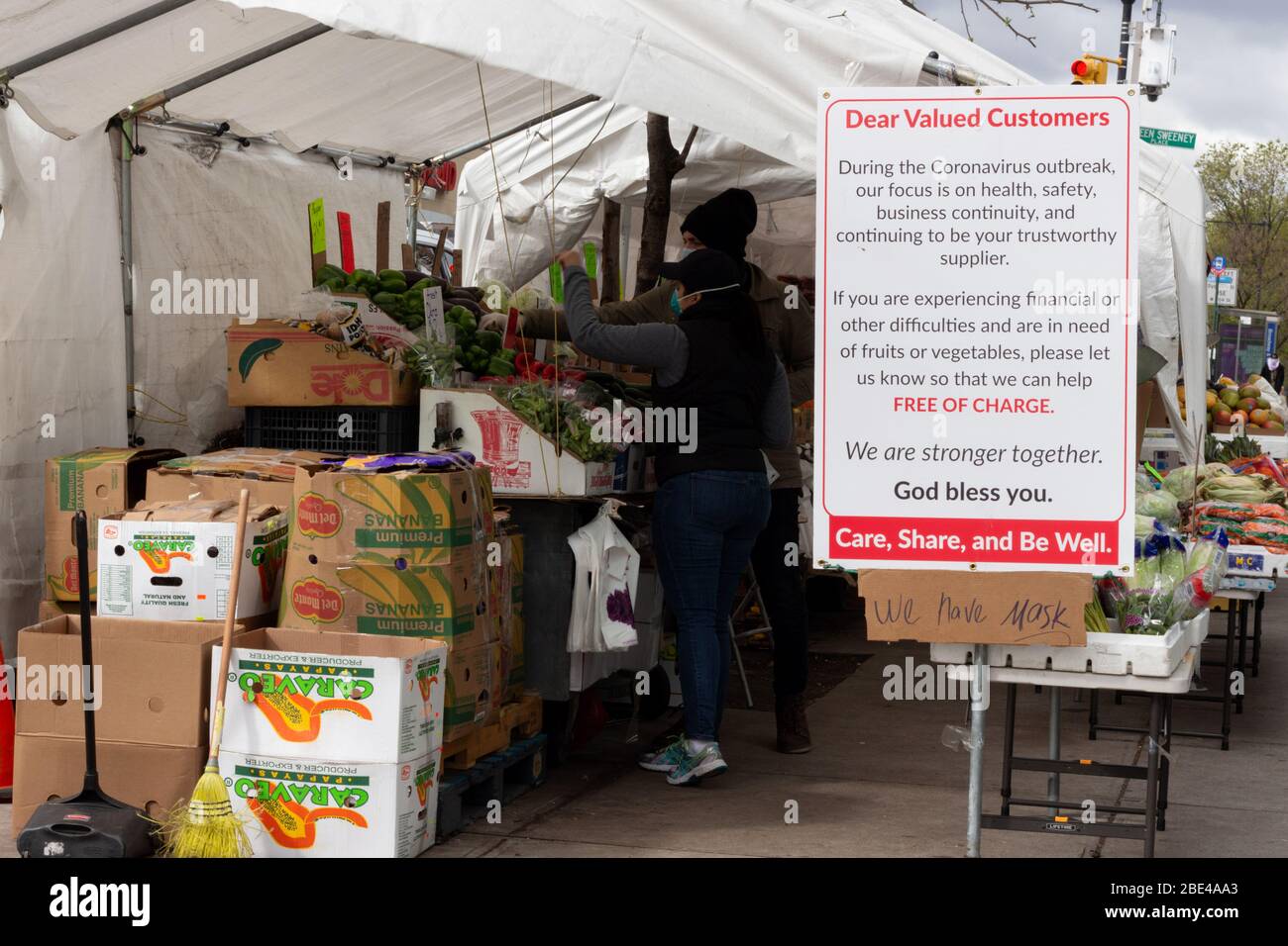 Eine Ecke produzieren Stand ein Schild bietet Hilfe für alle, die finanzielle Not aufgrund der Coronavirus oder Covid-19 Pandemie Stockfoto
