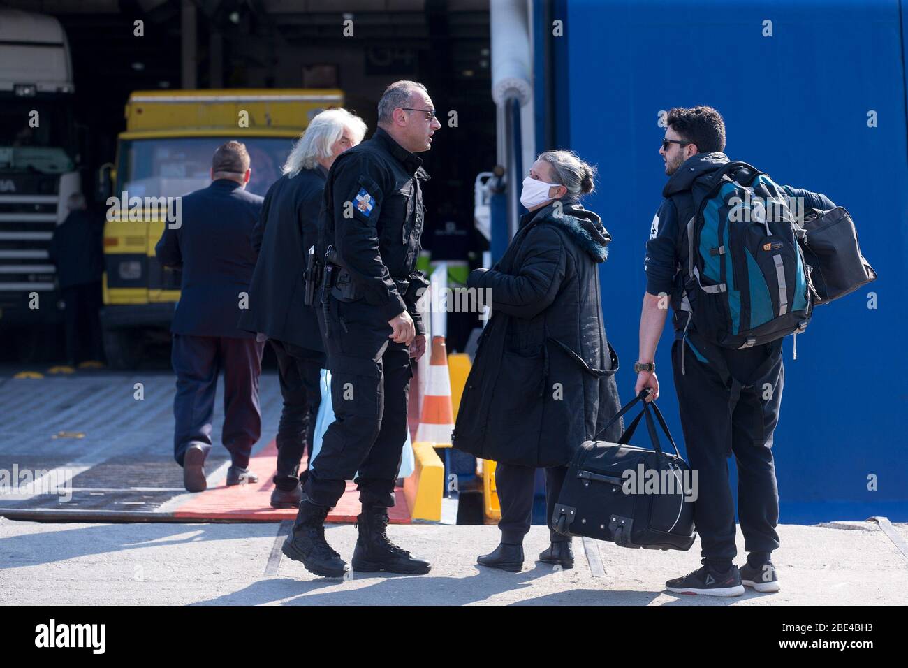 Piräus, Griechenland. April 2020. Ein Polizist (C) überprüft Passagiere eines Schiffes in Piräus, Griechenland, 11. April 2020. Die Gesamtzahl der COVID-19-Infektionen in Griechenland beträgt jetzt 2,081 und die Zahl der Todesfälle seit Beginn des Ausbruchs im Land am 26. Februar 93. Kredit: Marios Lolos/Xinhua/Alamy Live News Stockfoto