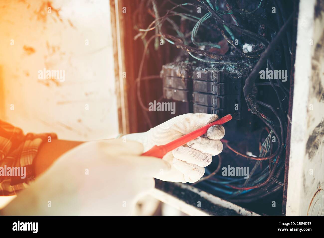 Techniker, der die Brandursache, den Kurzschluss, den Stromschlag und den Schaltschrank untersucht. Stockfoto