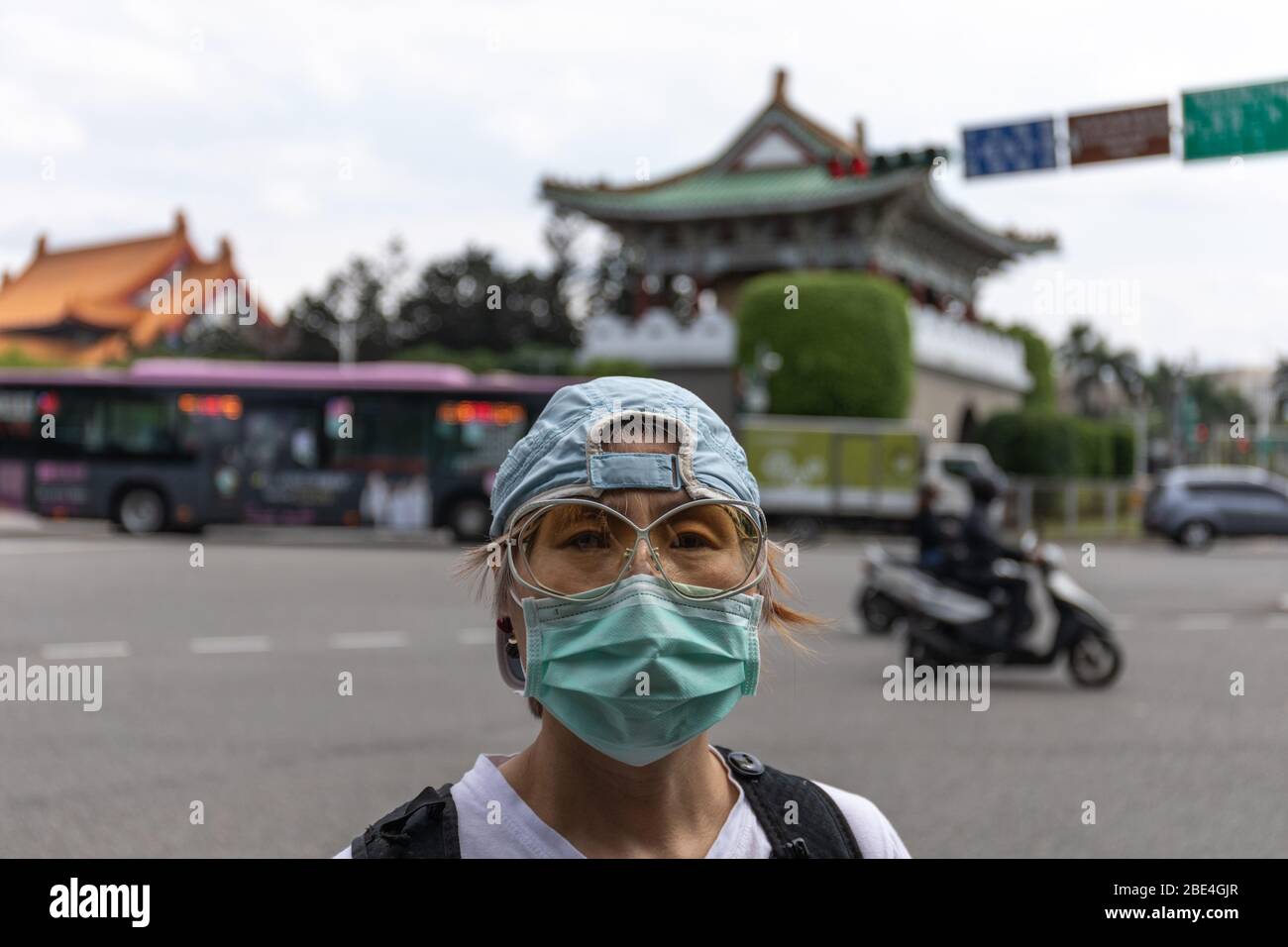 Taiwanesische Frau mit chirurgischer Maske zum Schutz vor dem Covid-19 Coronavirus vor dem Osttor von Taipei, Jingfumen. Stockfoto