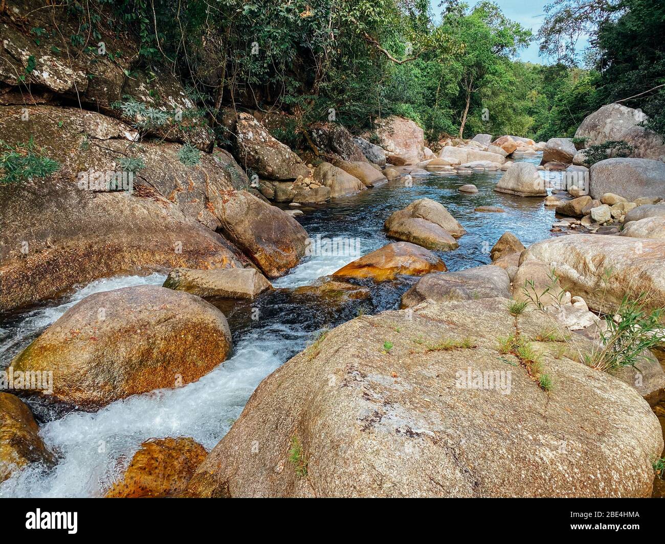 Ein kleiner Gebirgsfluss fließt zwischen großen Steinen in bergigen Gebieten durch den Wald. Natürliche Landschaft, mit einem sauberen Fluss eine schöne Landschaft, Stockfoto