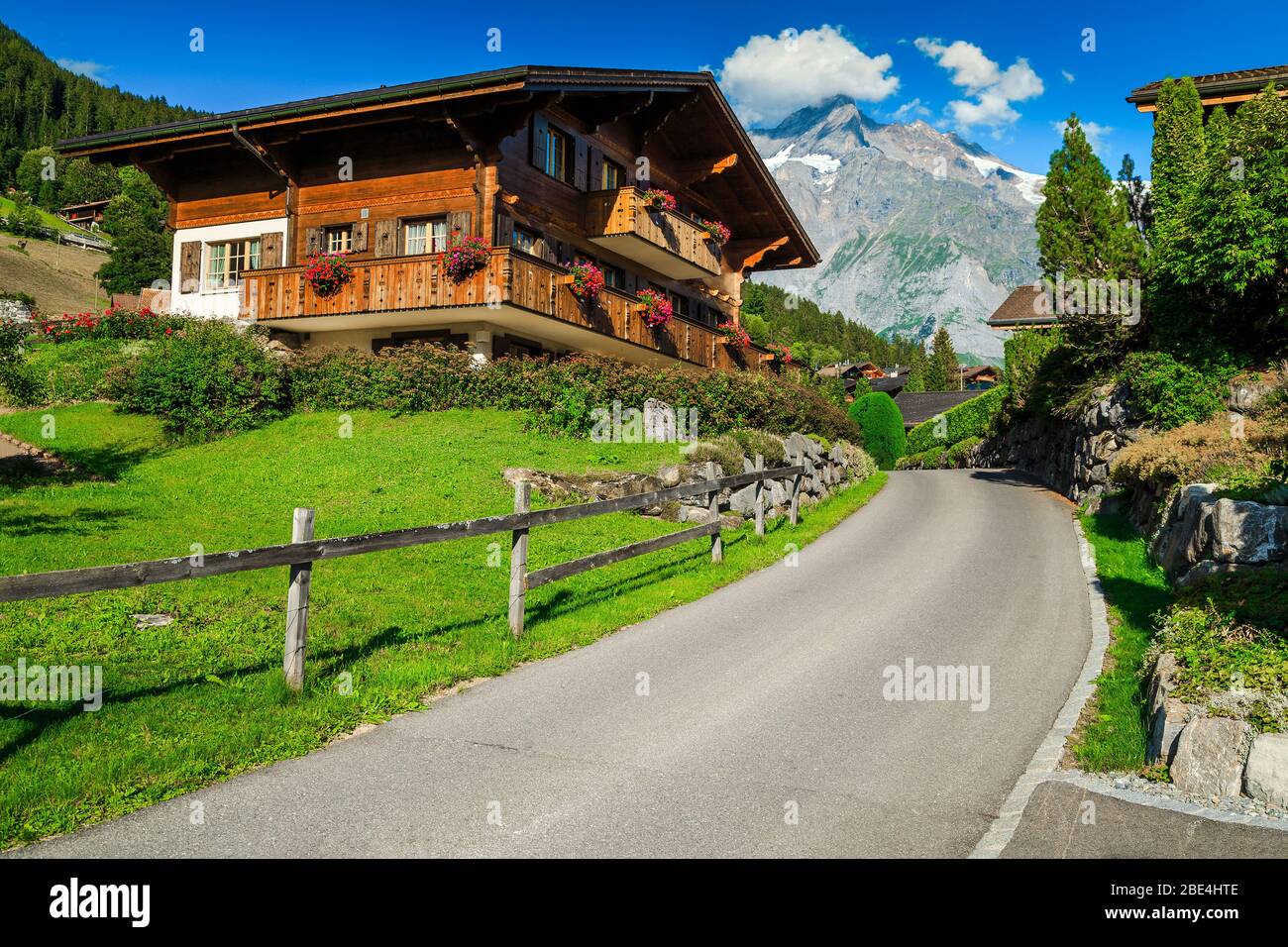 Gemütliche Straßenansicht mit Holzhütten und blumigen Ziergärten im Bergresort Grindelwald, Berner Oberland, Schweiz, Europa Stockfoto