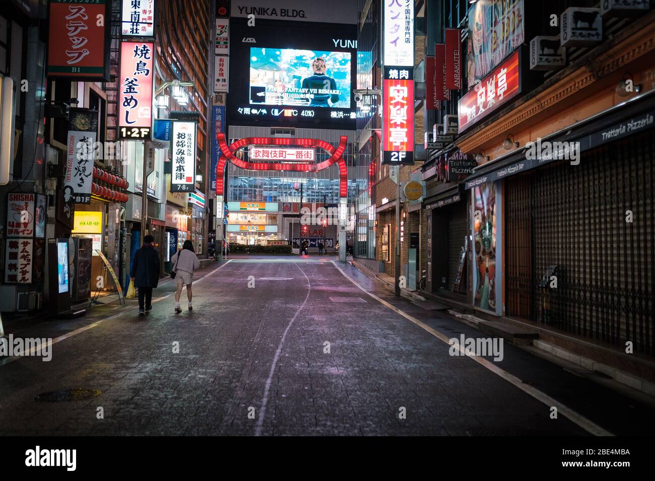 Tokio, Japan. April 2020. Ein Paar geht in der leeren Hauptstraße in Kabukicho (Shinjuku's Rotlichtviertel) in Tokio, Japan, am 11. April 2020. Der japanische Premierminister Shinzo Abe erklärte angesichts der Zunahme von Coronavirus- und COVID-19-Infektionen für mindestens einen Monat den Ausnahmezustand. Kredit: Aflo Co. Ltd./Alamy Live News Stockfoto