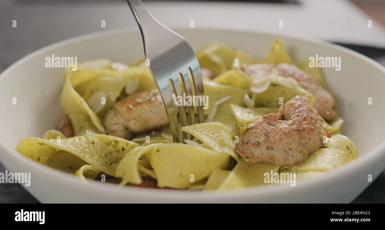 Tagliatelle mit Huhn und Pesto essen Stockfoto