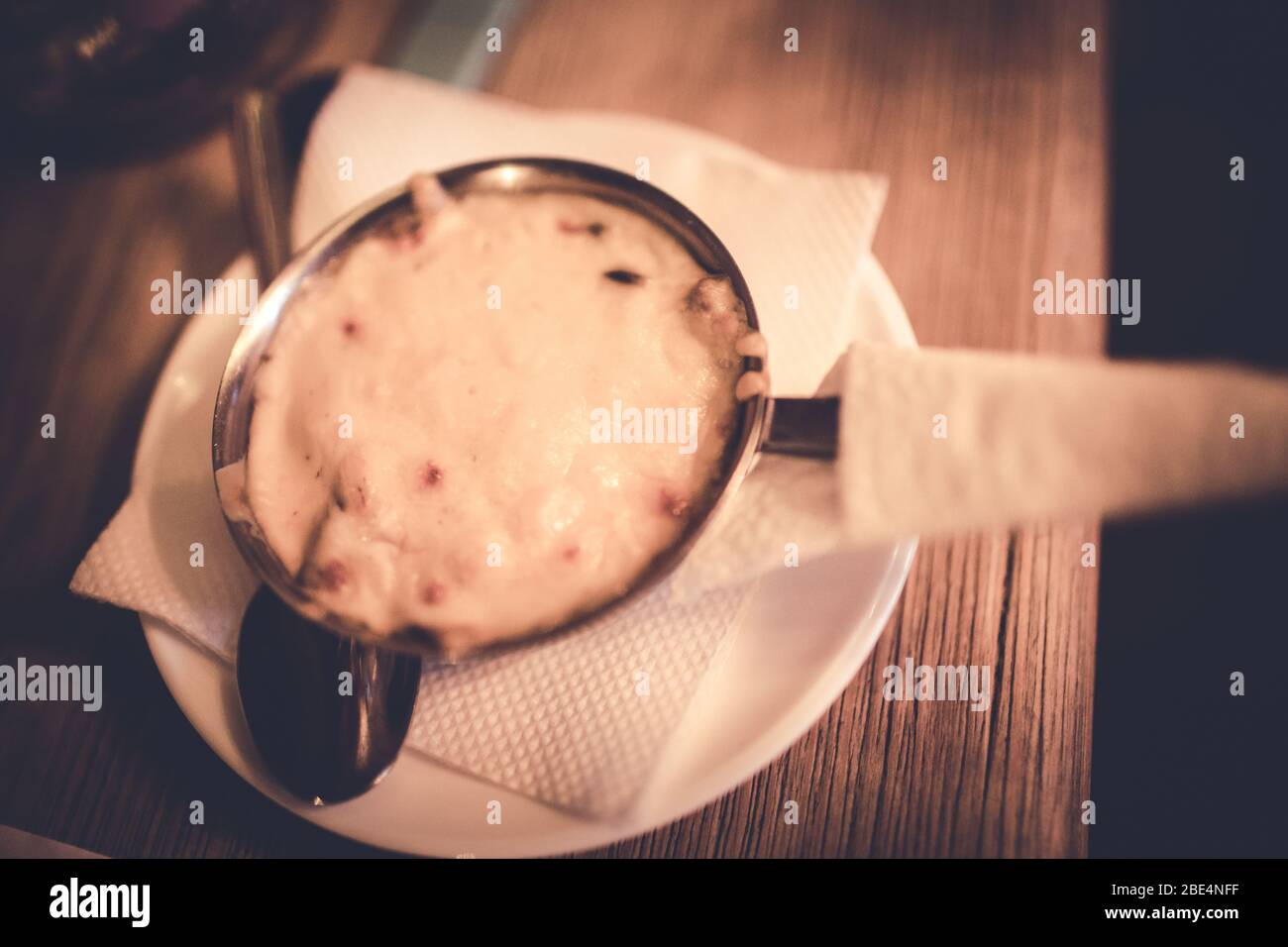 Julienne mit Käse und Pilzen in einer Metallschale. Stockfoto