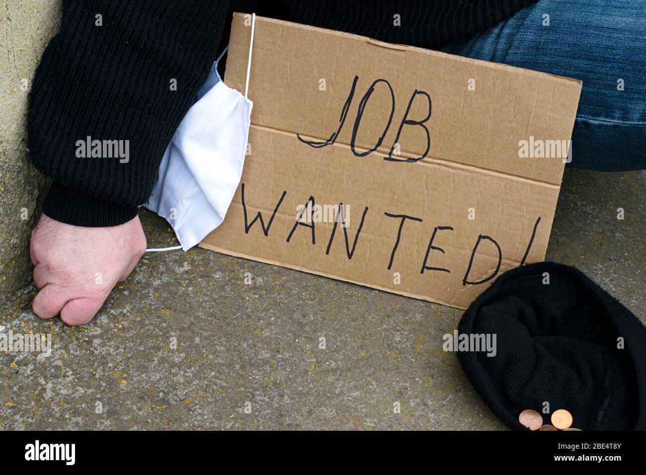 Arbeitslosigkeit Konzept und arbeitslose Coronavirus auf dem Boden neben ihm sitzen ein Pappteller mit der Aufschrift Job gewünscht, eine medizinische Hygiene Stockfoto